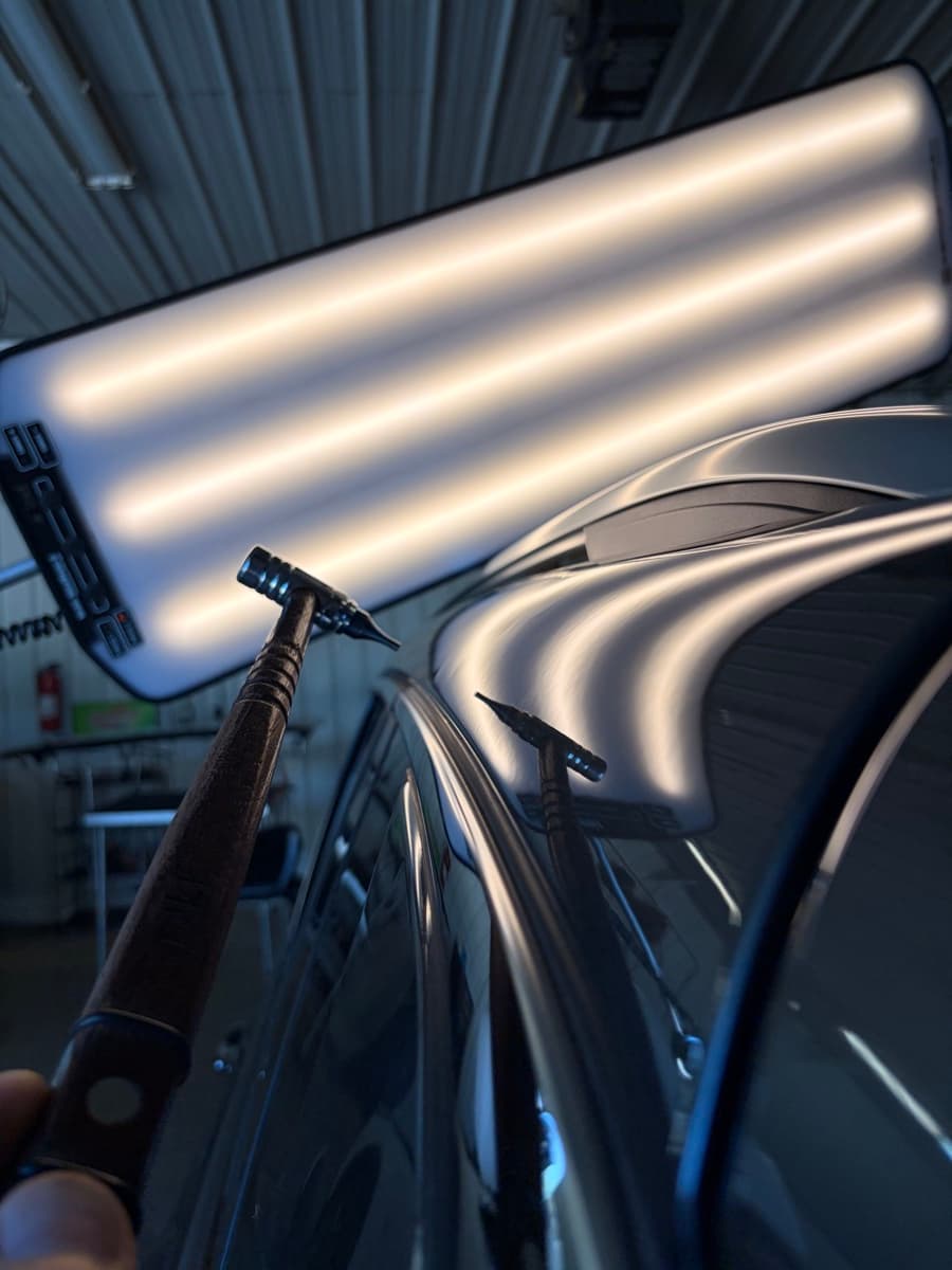 LED reflection board and PDR tools working a hail-dented roof